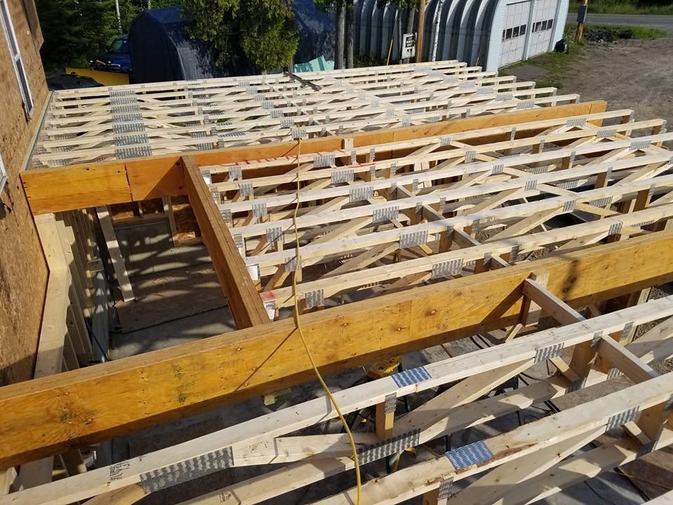 Wooden floor joists and beams under construction at a building site.