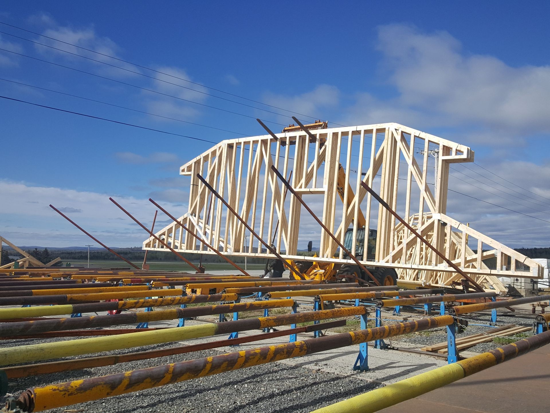 Wooden frame construction on a building site with support beams and blue sky in the background.